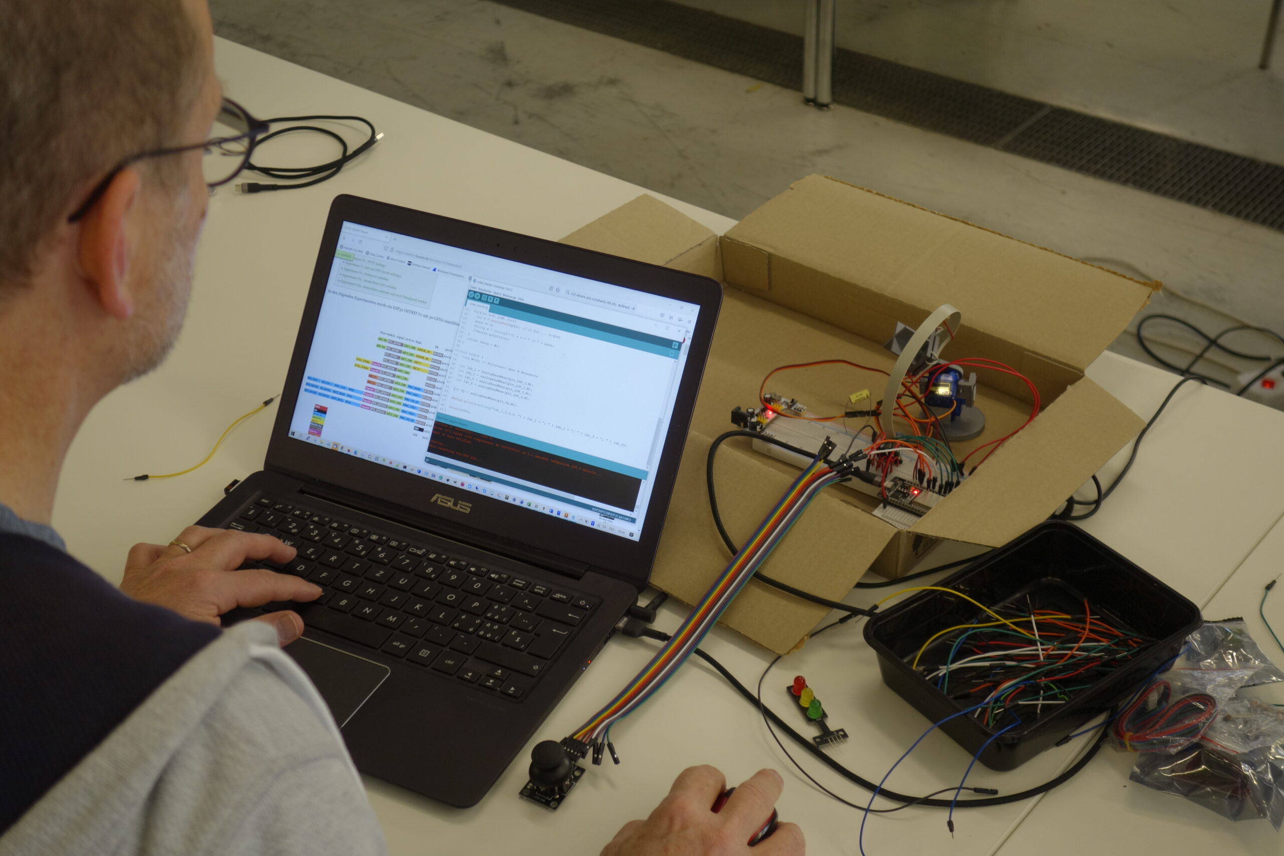 Block-basierte Programmierung am Laptop steuert eine Ampelschaltung mit LEDs.